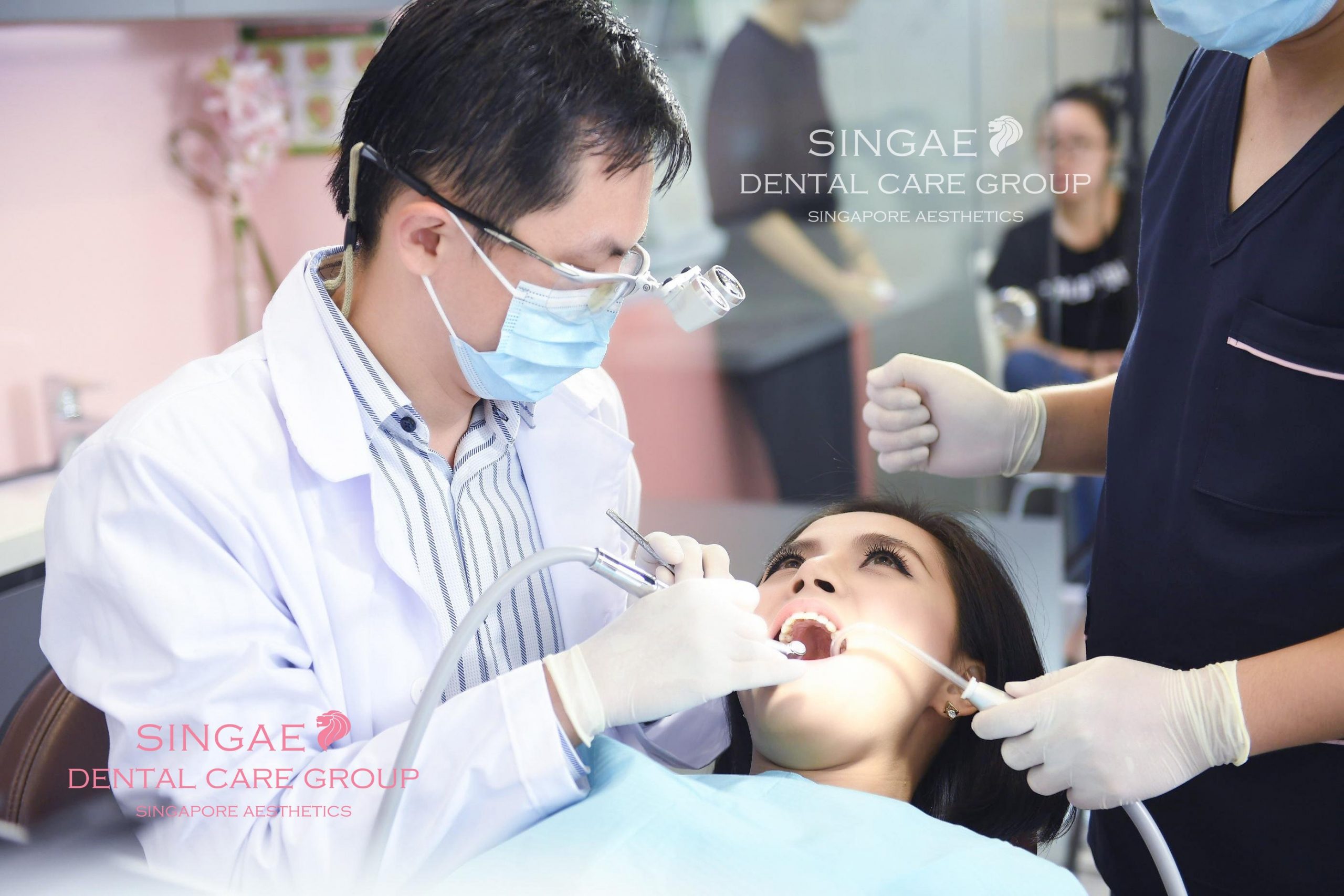Bác sĩ và y tác điều trị răng cho khách hàng