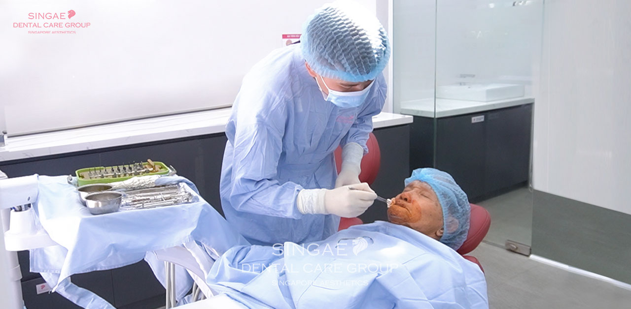 Bác sĩ tại Nha khoa Sinage sát khuẩn cho bệnh nhân chuẩn bị phẫu thuật